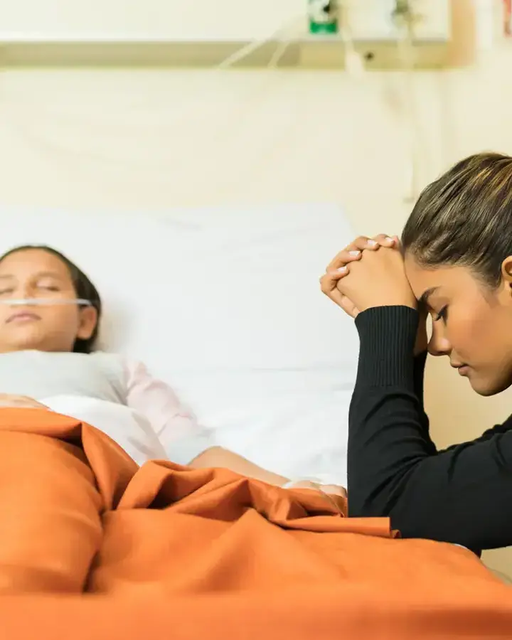 a woman in a hospital bed with her head in her hands