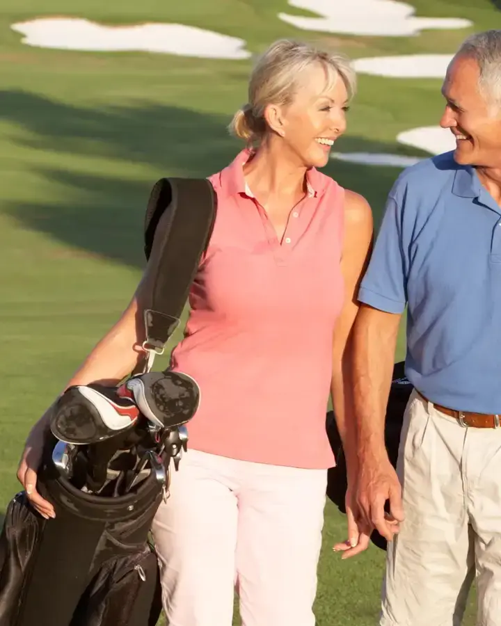 a man and woman walking on a golf course