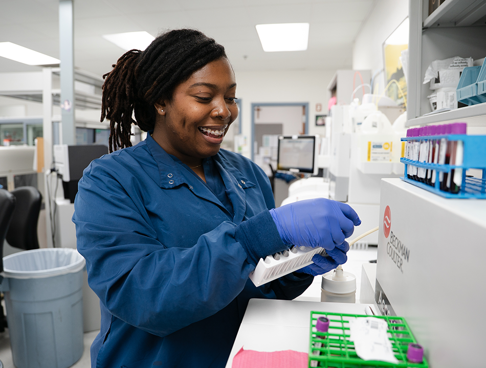A-woman-in-scrubs-holding-test-tubes