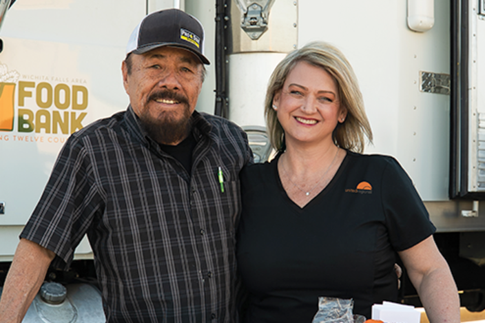 A-man-and-woman-posing-in-front-of-a-truck