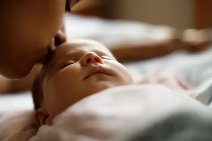 woman kissing baby