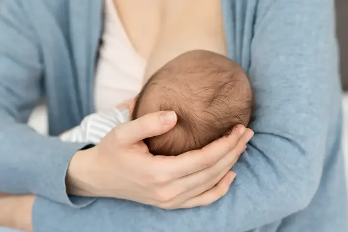 a woman holding a baby in her hands