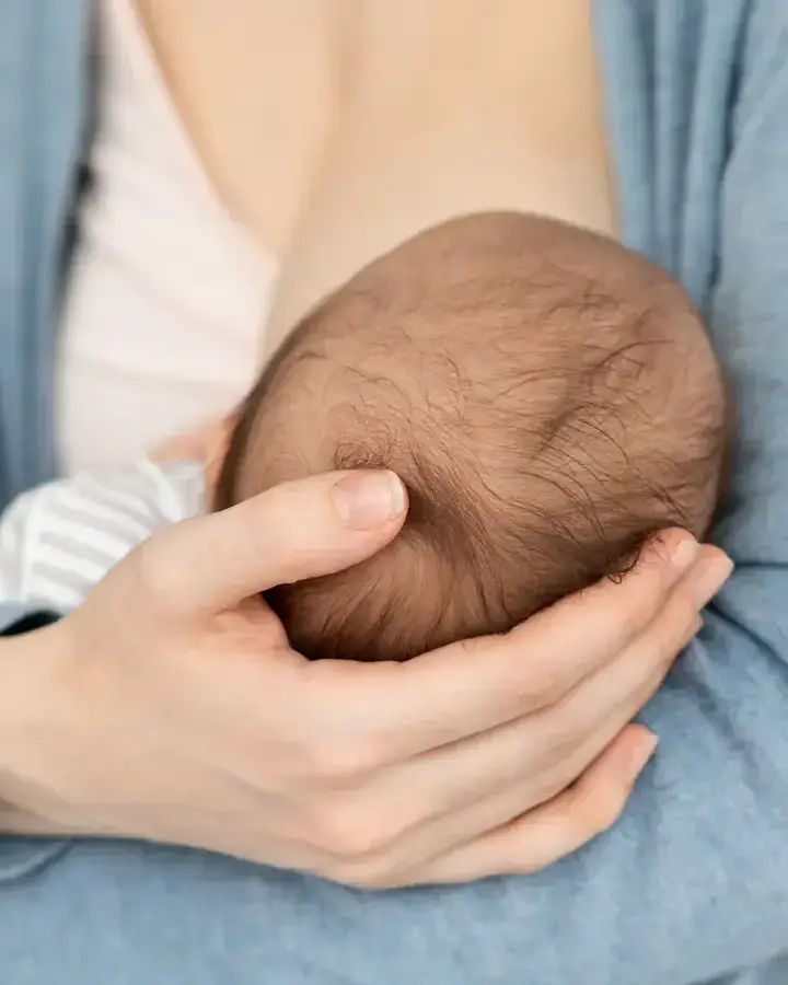 a woman holding a baby in her hands