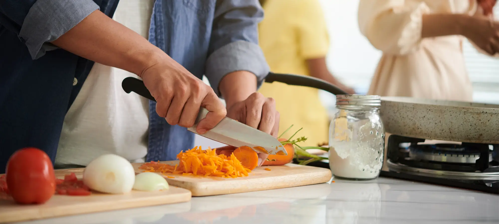 a woman cutting carrots on a cutting board