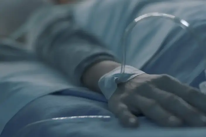 a person in a hospital bed with saline