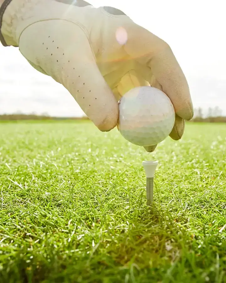 a golf ball and a golf club in the background