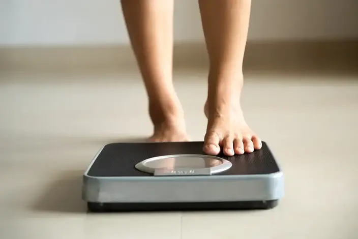 person stepping on to a scale